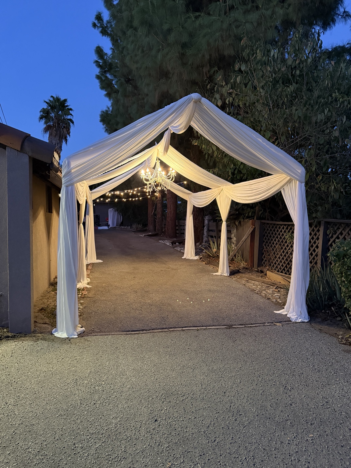 Draped outdoor entry with a chandelier